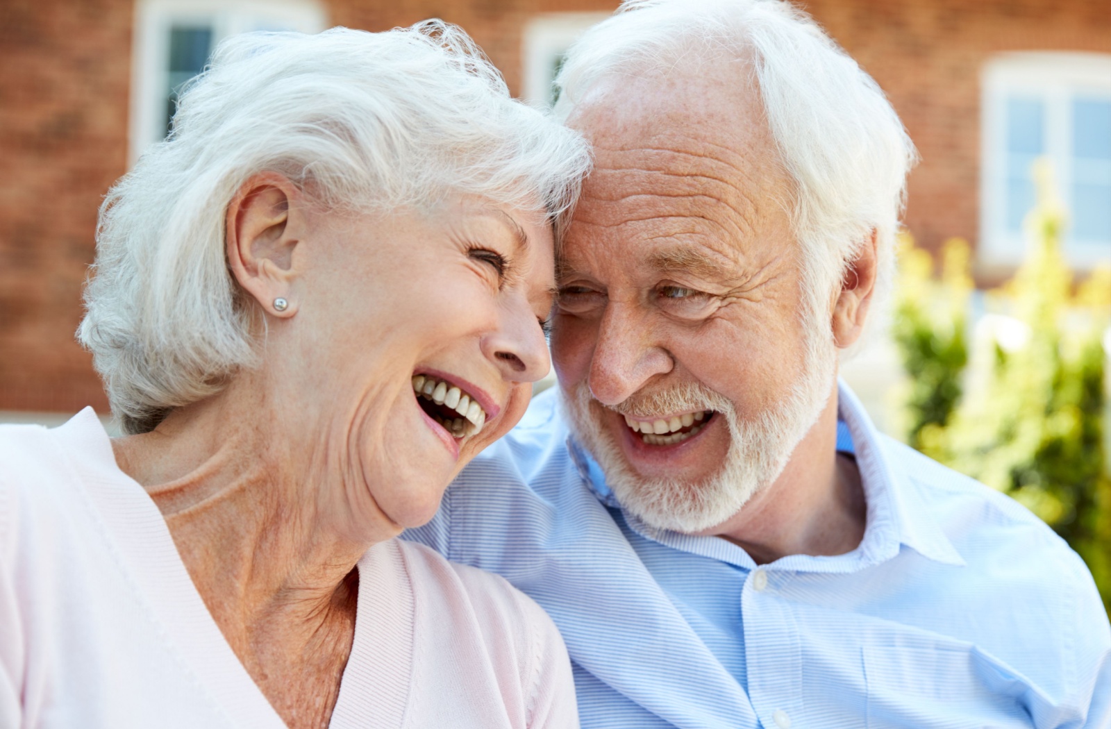 An older adult couple in assisted living looking at each other lovingly.