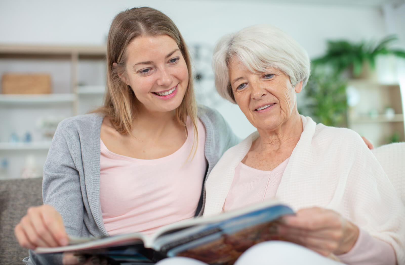 An older adult showing their adult child a scrapbook made during an craft class for seniors with dementia.